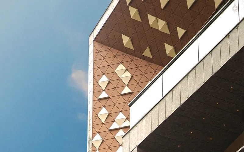 Faceted metal panel facade in terracotta and champagne gold, executed by Bhavy Vibes
