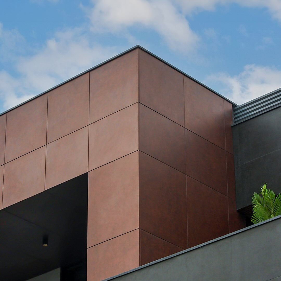 Terracotta panel clad residential facade against a clear sky
